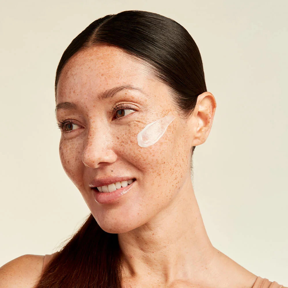 woman with a smear of Tru Alchemy's Retinol Reset on her face