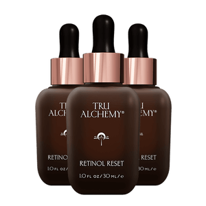 TruAlchemy Retinol Reset serum bottles with rose gold caps, three dark amber glass droppers arranged together